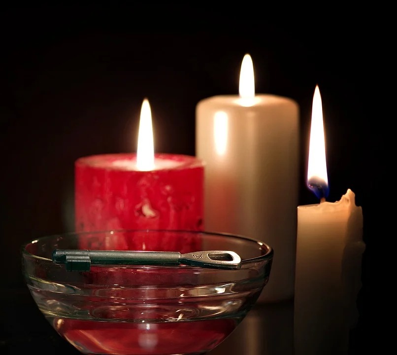Trzy zapalone świece, przed którymi znajduje się miseczka, na której leży klucz z dużym oczkiem, symbolizują wróżbę, którą wykonuje się w andrzejki.