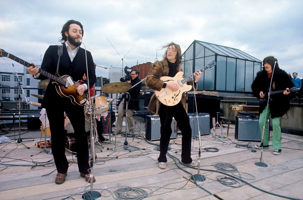Kadr przedstawiający Beatlesów podczas koncertu na dachu Apple Corps. 