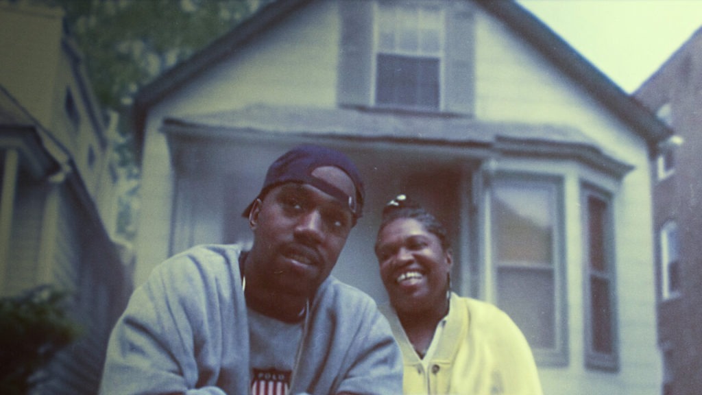 Kanye z kobietą siedzą przed domem.