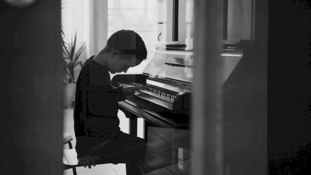 Chłopiec grający na pianinie w filmie "Pisklaki"